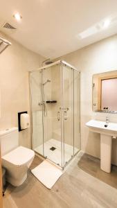 een badkamer met een douche, een toilet en een wastafel bij HOTEL MAUROS EL PUIG in El Puig