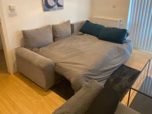 a bed in a living room with a couch at Luxury London Apartment - Steps To East Croydon Train Station in Croydon