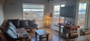 Una sala de estar con un sofá y un televisor de pantalla plana. en Casa Franca, en El Calafate
