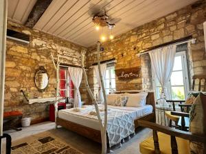 1 dormitorio con cama y pared de piedra en Marissa Boutique Hotel, en Cesme