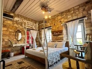 a bedroom with a bed and a stone wall at Marissa Boutique Hotel in Çeşme