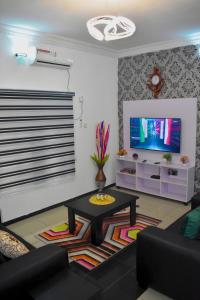 a living room with a table and a tv at Rehoboth Homes in Port Harcourt