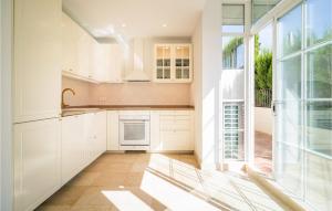 a kitchen with white cabinets and a large window at 2 Bedroom Gorgeous Apartment In Marbella in Marbella