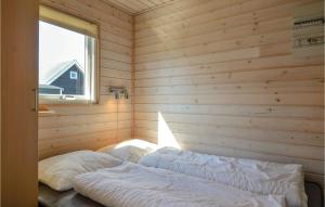 a room with two beds in a wooden room with a window at Hytte 8 in Thyborøn