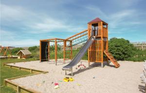 a playground with a slide in the sand at Hytte 8 in Thyborøn