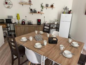 una cucina con tavolo in legno, sedie e frigorifero di Les Iris - Chambre Erable ad Avanton