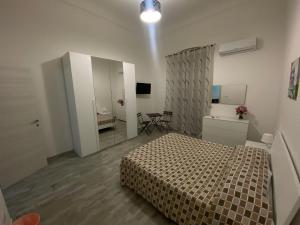 1 dormitorio con cama, tocador y espejo en Casaiole2023, en Taranto