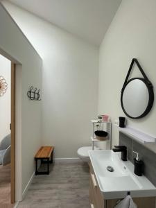 a white bathroom with a sink and a mirror at Les Iris - Chambre Erable in Avanton