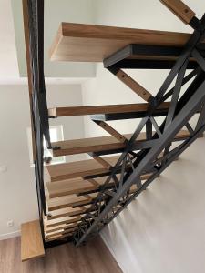 a staircase in a house with wood and black railings at Les Iris - Chambre Erable in Avanton