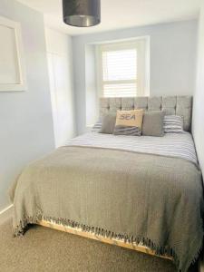 a bedroom with a bed with a sasha pillow on it at Delightful Dog Friendly Seaside Cottage in Shaldon Devon in Shaldon