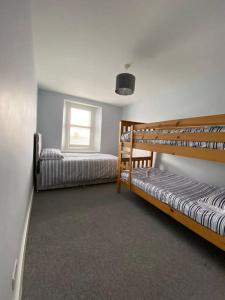 deux lits superposés dans une chambre avec fenêtre dans l'établissement Delightful Dog Friendly Seaside Cottage in Shaldon Devon, à Shaldon