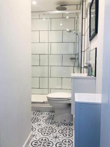 uma casa de banho com um WC, um lavatório e um espelho. em Delightful Dog Friendly Seaside Cottage in Shaldon Devon em Shaldon