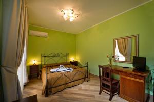 Un dormitorio con una cama, un escritorio y un espejo. en Al Cantuccio, en Castelluzzo