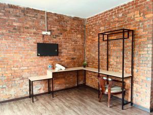 a brick wall with a desk and a chair in a room at Big Dreams Garden Stay in Tanah Rata