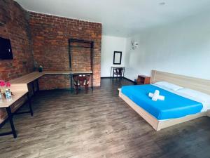 a bedroom with a blue bed and a brick wall at Big Dreams Garden Stay in Tanah Rata