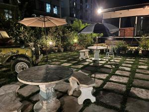 un patio de piedra con mesa y sombrilla en Big Dreams Garden Stay en Tanah Rata