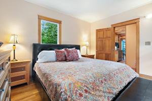 a bedroom with a bed and a dresser and a window at Geneva Retreat in Bellingham