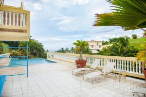un patio con sillas y una piscina en Puntas Rincon Villa 301 with private rooftop terrace, en Rincón