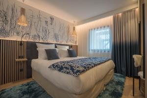 a bedroom with a large bed with a blue and white blanket at EDEN VILLA in Sainte-Maxime
