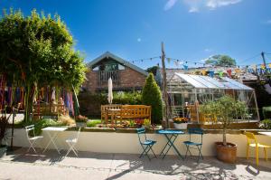 a garden with chairs and a table and a greenhouse at The Cartford Inn in Great Eccleston