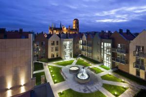 a view of the courtyard of a building with a fountain at Apartamenty Szeroka - Old Town Holidays Home in Gdańsk