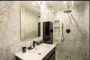 a white bathroom with a sink and a shower at Deauville : magnifique studio en face du Casino ! in Deauville +22 photos