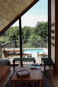 un patio con mesa, sillas y piscina en Casa Friendly avec sa piscine chauffée …, en Les Croix Chemins