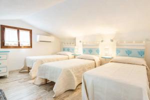 three beds in a room with white walls at Cala Paradiso Apartment "Casa Agave" - SeaView, Wifi, AC in San Teodoro +47 photos