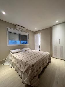 a bedroom with a large bed with a window at MINHA CASA NA PRAIA in Riviera de São Lourenço