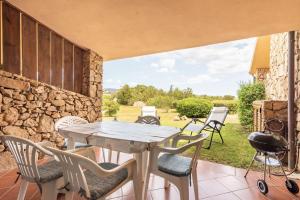 a patio with a table and chairs and a grill at Cala Paradiso Apartment "Casa Agave" - SeaView, Wifi, AC in San Teodoro