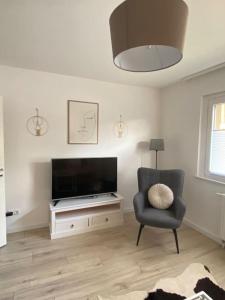 a living room with a chair and a flat screen tv at Harzperle 2 II zentrales 3 Zi Apartment II Familien in Bad Harzburg