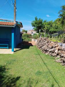 un mur en pierre à côté d'une maison bleue dans l'établissement Rancho Lux, à Águas de Lindóia