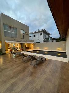 a house with a swimming pool and some chairs at MINHA CASA NA PRAIA in Riviera de São Lourenço