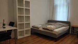 een slaapkamer met een bed en een boekenplank bij CozyNite Premium Apartment Hauptbahnhof 1+2 in Wenen