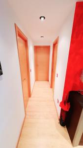 ein langer Flur mit einer rot-weißen Wand in der Unterkunft Diana´s Luxury Apartment in Torrejón de Ardoz