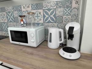 a microwave and a coffee maker on a counter at Appartement lumineux Parking Privé Gratuit in Bourg-en-Bresse