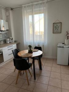 a kitchen with a table and chairs in a room at Appartement lumineux Parking Privé Gratuit in Bourg-en-Bresse