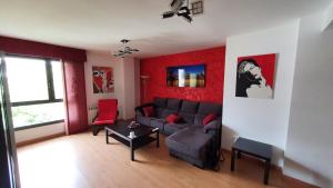 Diana´s Luxury Apartment في توريخون ذي أرذوث: غرفة معيشة مع أريكة رمادية وجدران حمراء
