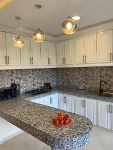 a kitchen with white cabinets and a granite counter top at Incantevole villa Safi Sidi Bouzid near beach in Safi