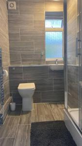 baño con aseo y lavabo y ventana en Chic City Retreat Immaculate 2-Bed Oasis in London, en Londres