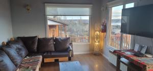Una sala de estar con un sofá y una ventana grande. en Casa Franca, en El Calafate