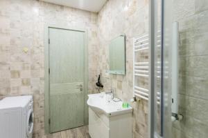 a bathroom with a sink and a toilet and a mirror at The Urban Retreat in Tbilisi City +17 photos