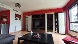 ein Wohnzimmer mit schwarzem Couchtisch und roten Wänden in der Unterkunft Diana´s Luxury Apartment in Torrejón de Ardoz + 26 Fotos