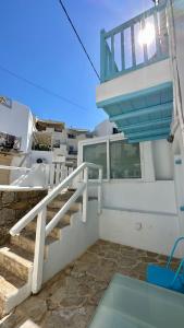 a balcony with stairs and a sink on a house at Fayrouz Psarrou Beach Mykonos in Mikonos