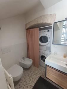 a bathroom with a toilet sink and a washing machine at Sull'arco della Gnostra in Noci