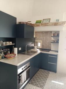 una cucina con armadi blu e lavandino di Sull'arco della Gnostra a Noci