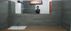 Eine Frau, die ein Foto in einem Badezimmerspiegel macht. in der Unterkunft Studio Standard - AMI APPARTHOTEL in Tôlagnaro