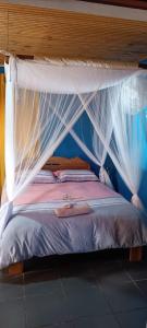 ein Bett mit einem Baldachin und weißen Moskitonetzen in der Unterkunft Studio Standard - AMI APPARTHOTEL in Tôlagnaro