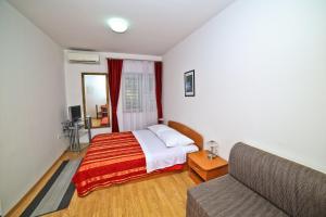 a bedroom with a bed and a couch at Apartments Bozikovic in Podstrana