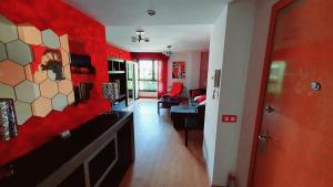 Diana´s Luxury Apartment في توريخون ذي أرذوث: غرفة معيشة مع جدران حمراء وغرفة مع أريكة
